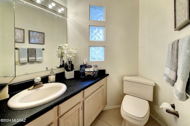 bathroom with tile patterned flooring, vanity, and toilet