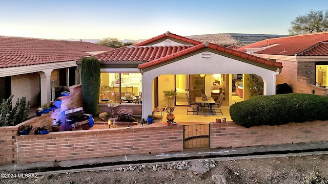 view of back house at dusk