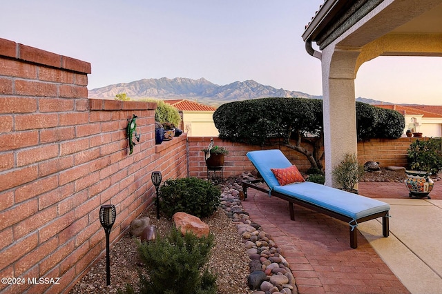 patio terrace at dusk featuring a mountain view