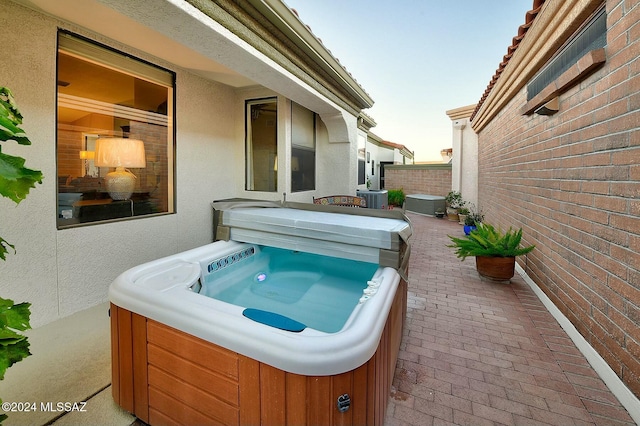 view of patio / terrace featuring central AC and a hot tub