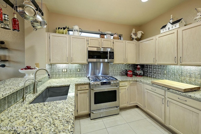 4115 S Constancia Ct, Green Valley, AZ 85622 - kitchen with stainless steel appliances, a sink, light tile patterned flooring, backsplash, and light stone counters