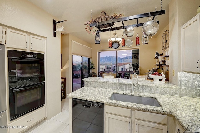 kitchen with black appliances, light tile patterned flooring, light stone countertops, and sink