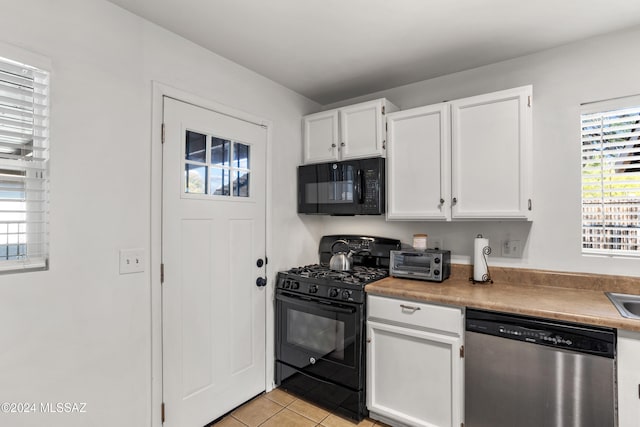 kitchen featuring light tile patterned floors, white cabinetry, and black appliances