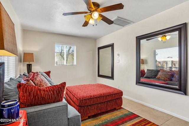 living room with ceiling fan, light tile patterned floors, and a brick fireplace