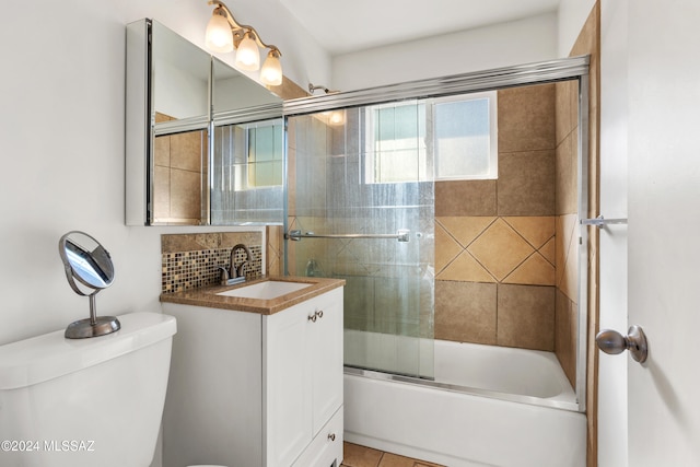 full bathroom with tile patterned flooring, toilet, combined bath / shower with glass door, and vanity