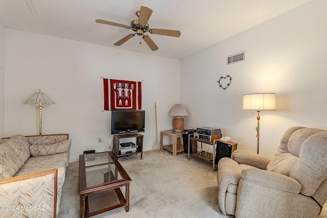 carpeted living room with a textured ceiling and ceiling fan