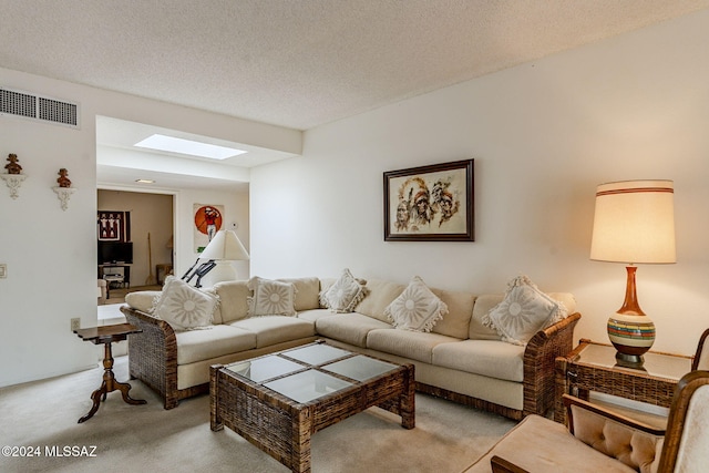 living room with light colored carpet, a textured ceiling, and a skylight