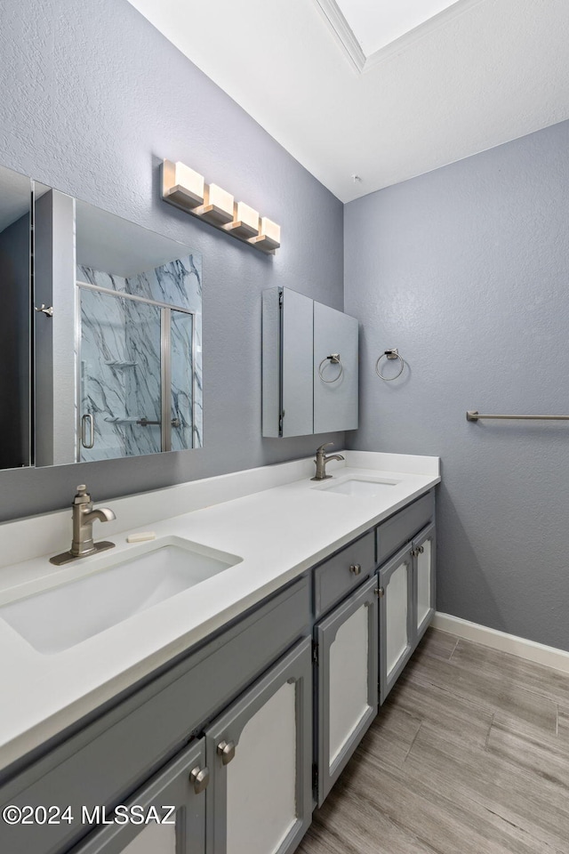 bathroom featuring wood-type flooring, vanity, and an enclosed shower