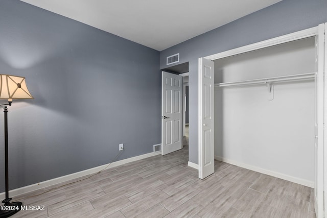 unfurnished bedroom with a closet and light wood-type flooring