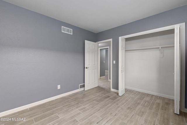 unfurnished bedroom featuring light hardwood / wood-style floors and a closet