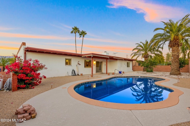 pool at dusk with a patio