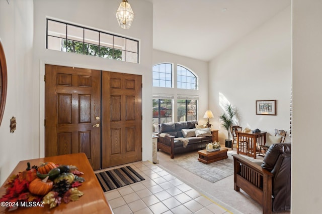 entryway with light tile patterned flooring and a towering ceiling