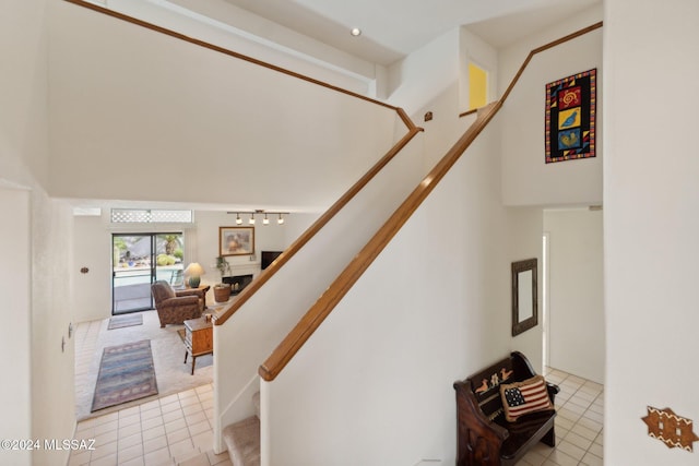 stairs featuring tile patterned flooring and a fireplace