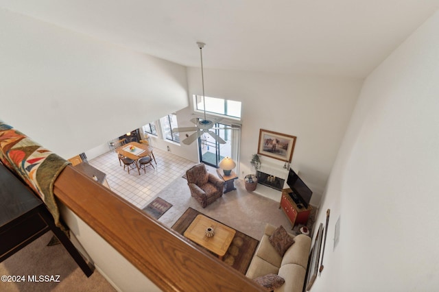 living room featuring carpet floors, ceiling fan, and high vaulted ceiling