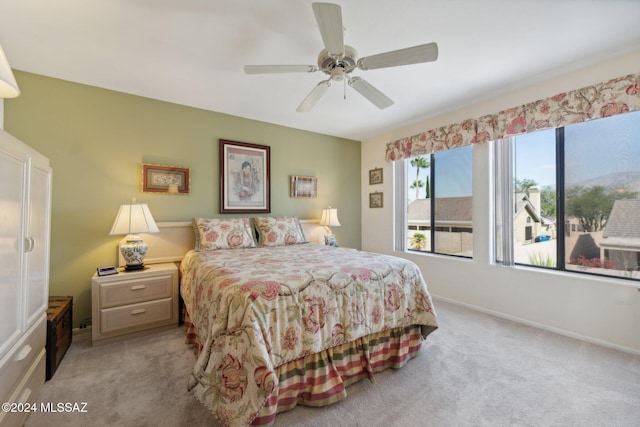 bedroom with light carpet, ceiling fan, and baseboards