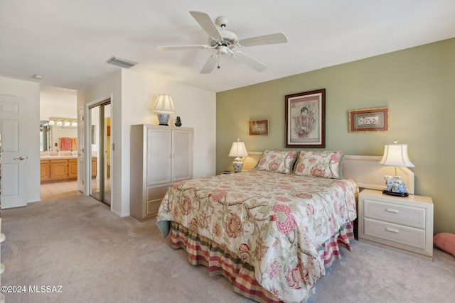 bedroom featuring visible vents, connected bathroom, light colored carpet, ceiling fan, and a sink