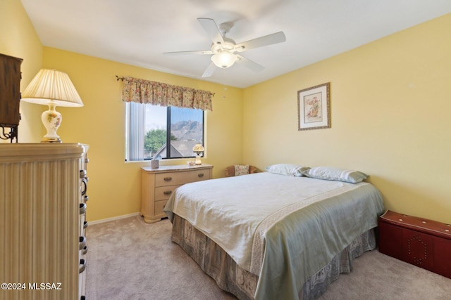 bedroom featuring a ceiling fan, light colored carpet, and baseboards