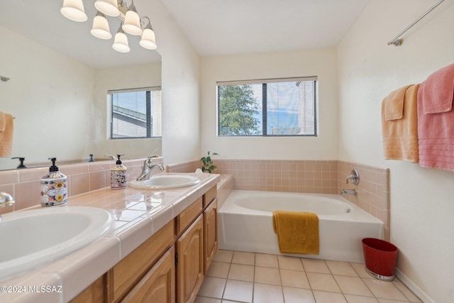 bathroom featuring a bathtub, vanity, a healthy amount of sunlight, and tile patterned flooring