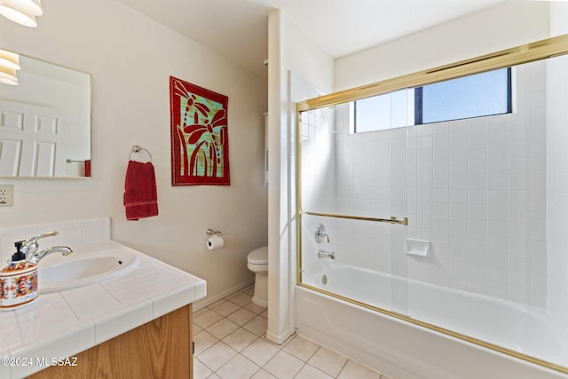 bathroom with bath / shower combo with glass door, baseboards, toilet, tile patterned flooring, and vanity