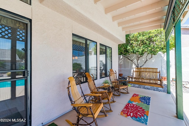 view of patio featuring covered porch and fence