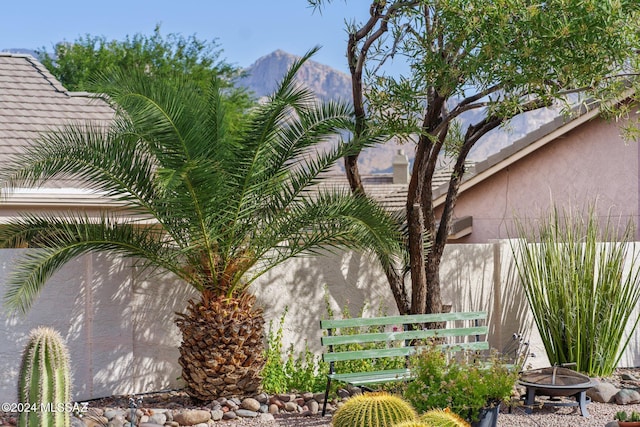 exterior space featuring a fire pit, fence, and a mountain view