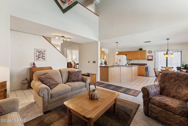 interior space featuring a chandelier, a wealth of natural light, light colored carpet, and a high ceiling