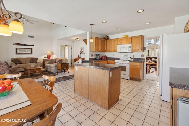 kitchen with white appliances, dark countertops, open floor plan, a sink, and light tile patterned flooring