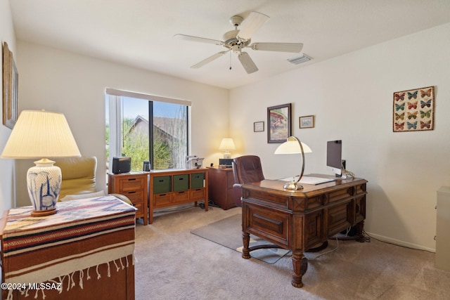 office area featuring visible vents, ceiling fan, light carpet, and baseboards