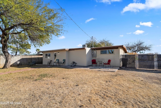 rear view of property featuring a yard and a patio