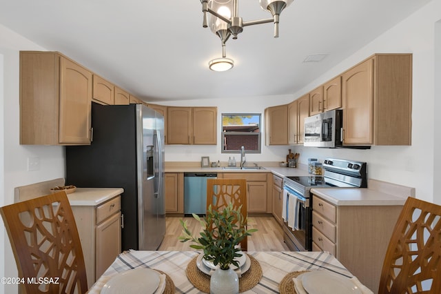 kitchen featuring light brown cabinetry, sink, a notable chandelier, stainless steel appliances, and light hardwood / wood-style floors