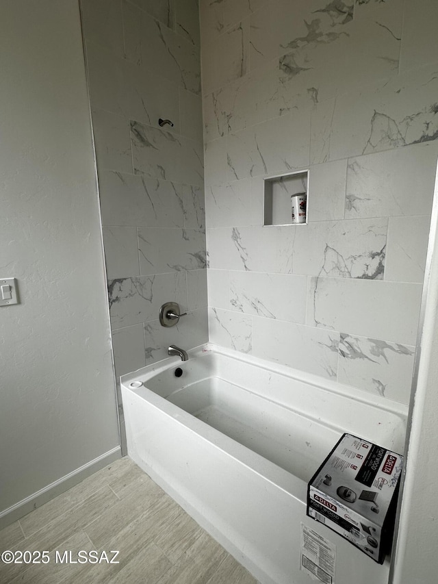 full bathroom featuring  shower combination, wood finished floors, and baseboards