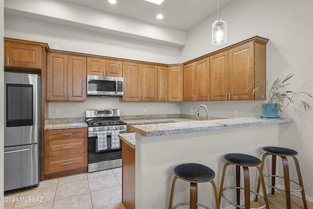 kitchen with kitchen peninsula, light stone counters, and appliances with stainless steel finishes