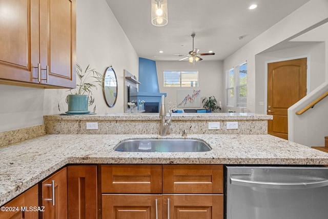 kitchen featuring light stone countertops, ceiling fan, sink, and dishwasher