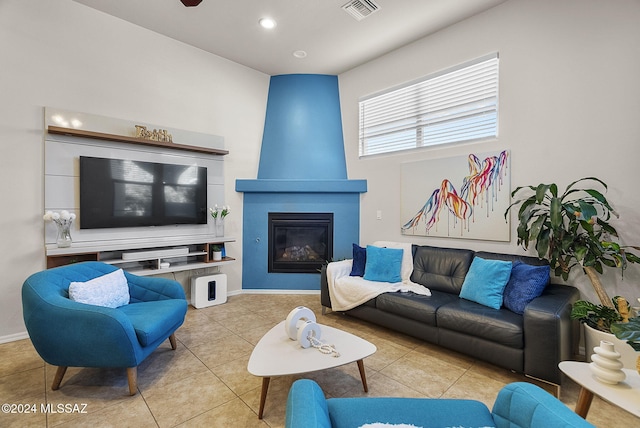 living room with a fireplace and light tile patterned flooring