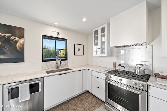 kitchen with light stone countertops, sink, white cabinetry, and stainless steel appliances