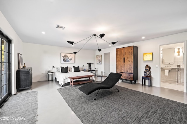 bedroom featuring ensuite bathroom and concrete flooring