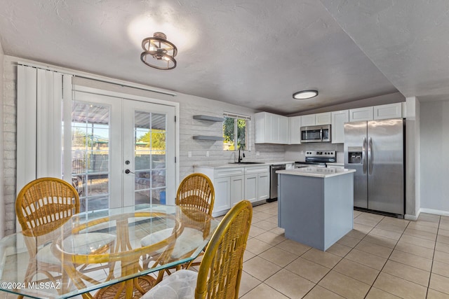 kitchen featuring a center island, french doors, white cabinets, sink, and stainless steel appliances