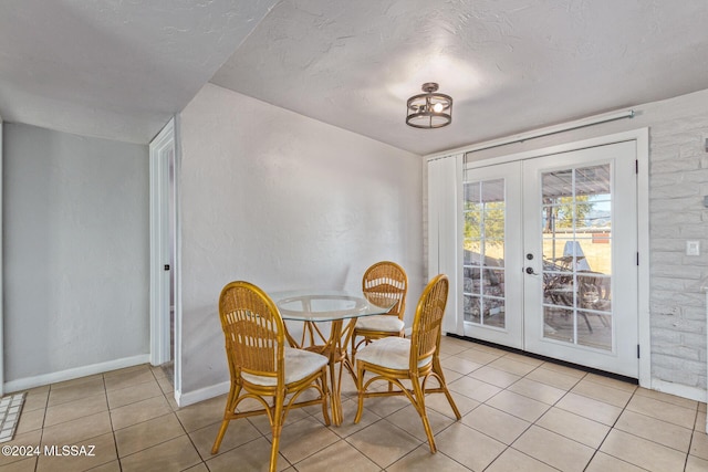 dining room featuring light tile patterned floors, a textured ceiling, and french doors