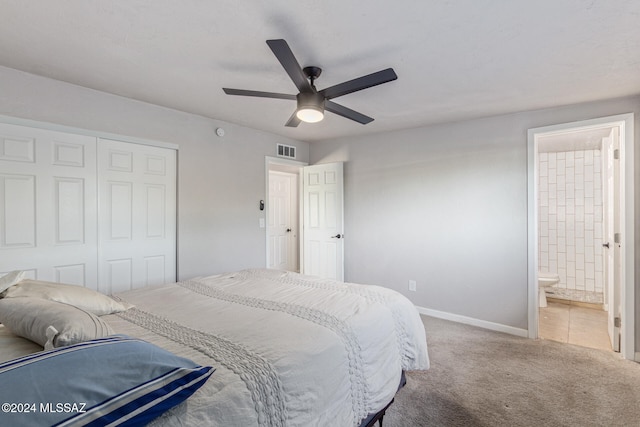 bedroom with carpet flooring, ceiling fan, a closet, and ensuite bath