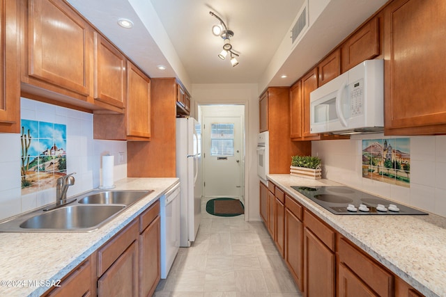 kitchen with white appliances, sink, backsplash, and light stone counters