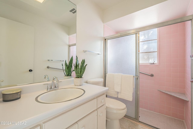 bathroom with walk in shower, vanity, and toilet