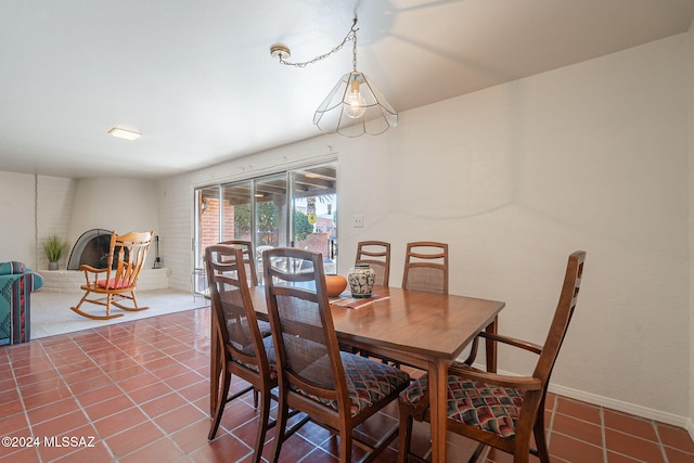 tiled dining room with a fireplace