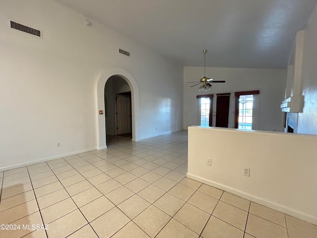 spare room with light tile patterned floors, high vaulted ceiling, and ceiling fan