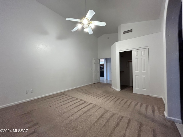 interior space with carpet floors, ceiling fan, a closet, and high vaulted ceiling