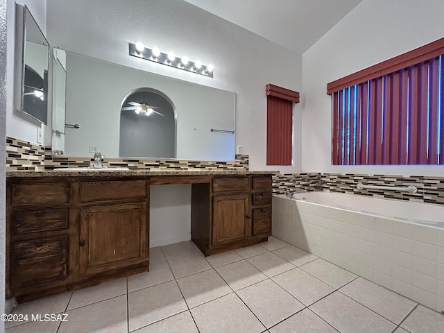 bathroom with tiled bath, ceiling fan, tile patterned flooring, and vanity