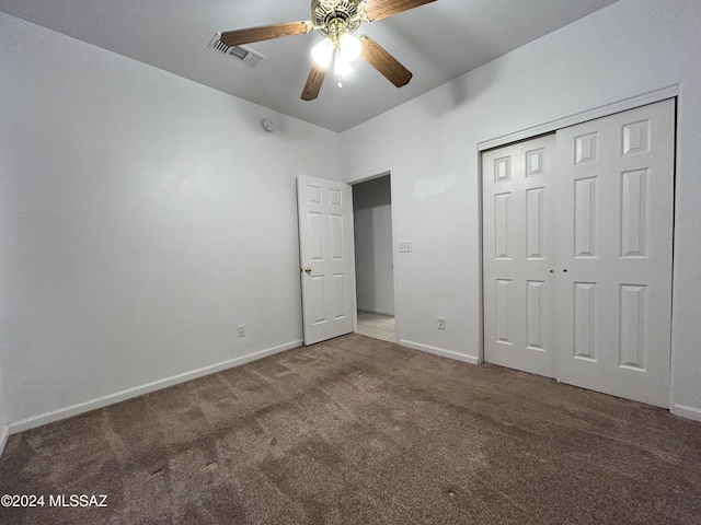 unfurnished bedroom featuring carpet, ceiling fan, and a closet