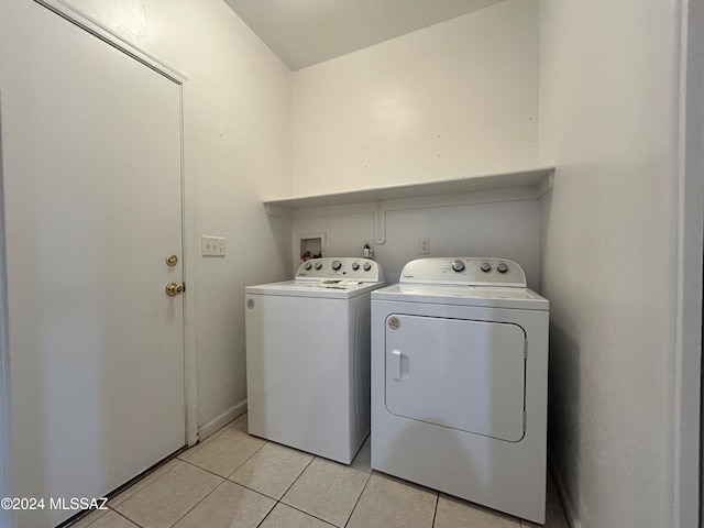 washroom featuring washing machine and dryer and light tile patterned floors