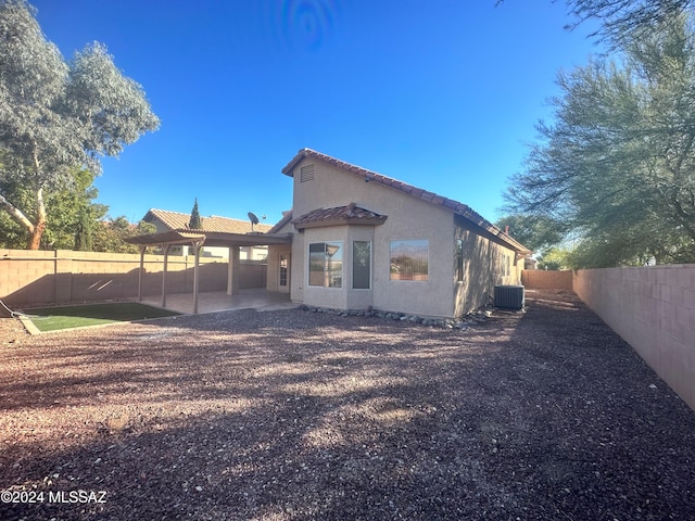 rear view of property featuring a patio and central air condition unit