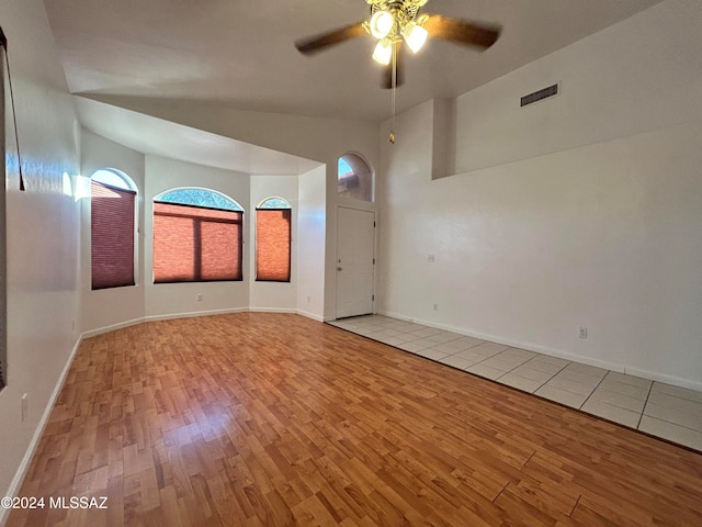 spare room with ceiling fan, light hardwood / wood-style floors, and lofted ceiling