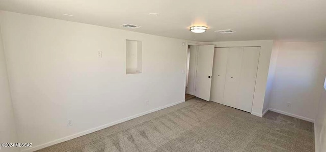 unfurnished bedroom with a closet and light carpet